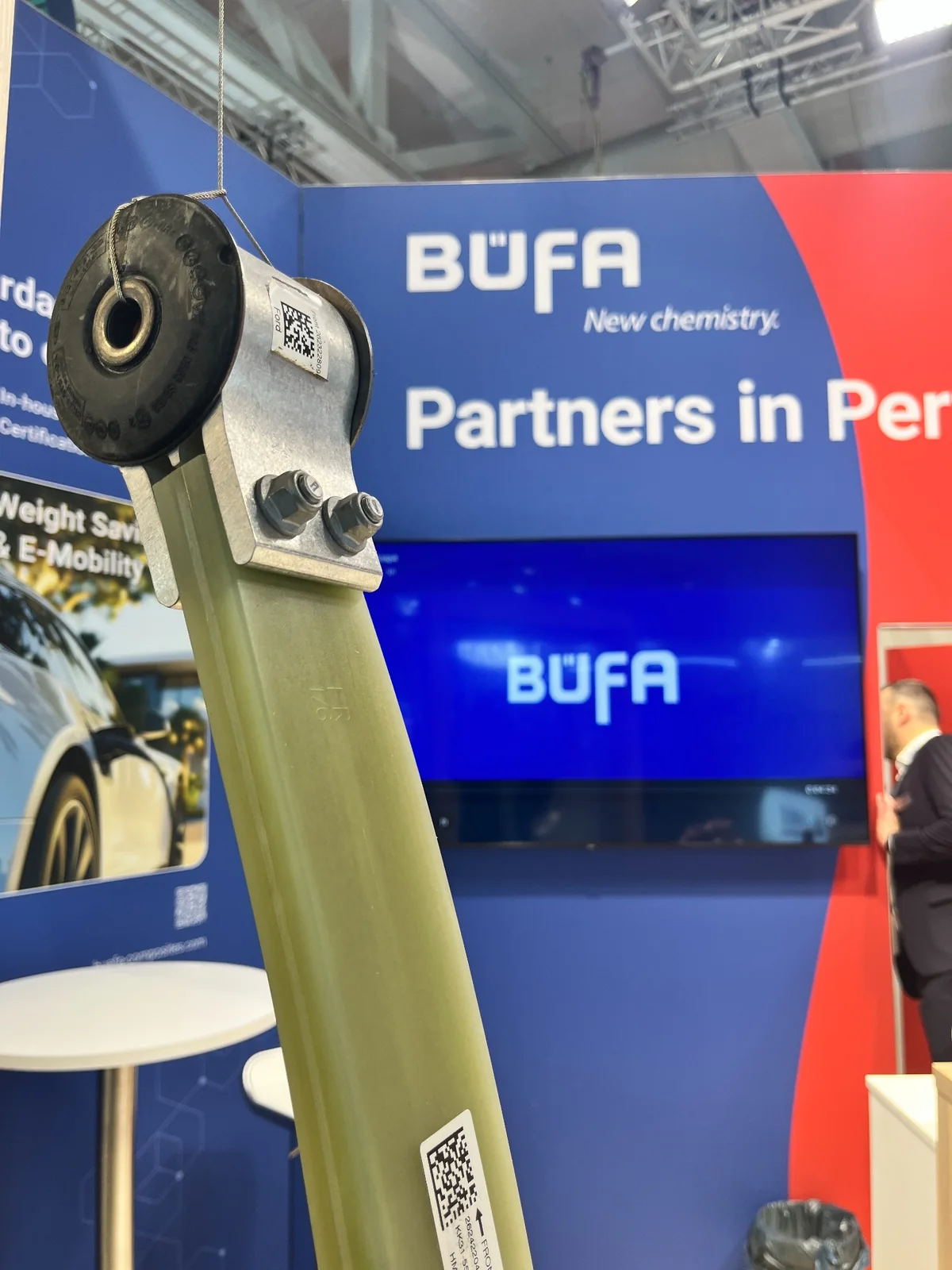 Close-up of the composite longitudinal leaf spring in front of the B&Uuml;FA and AOC stand.