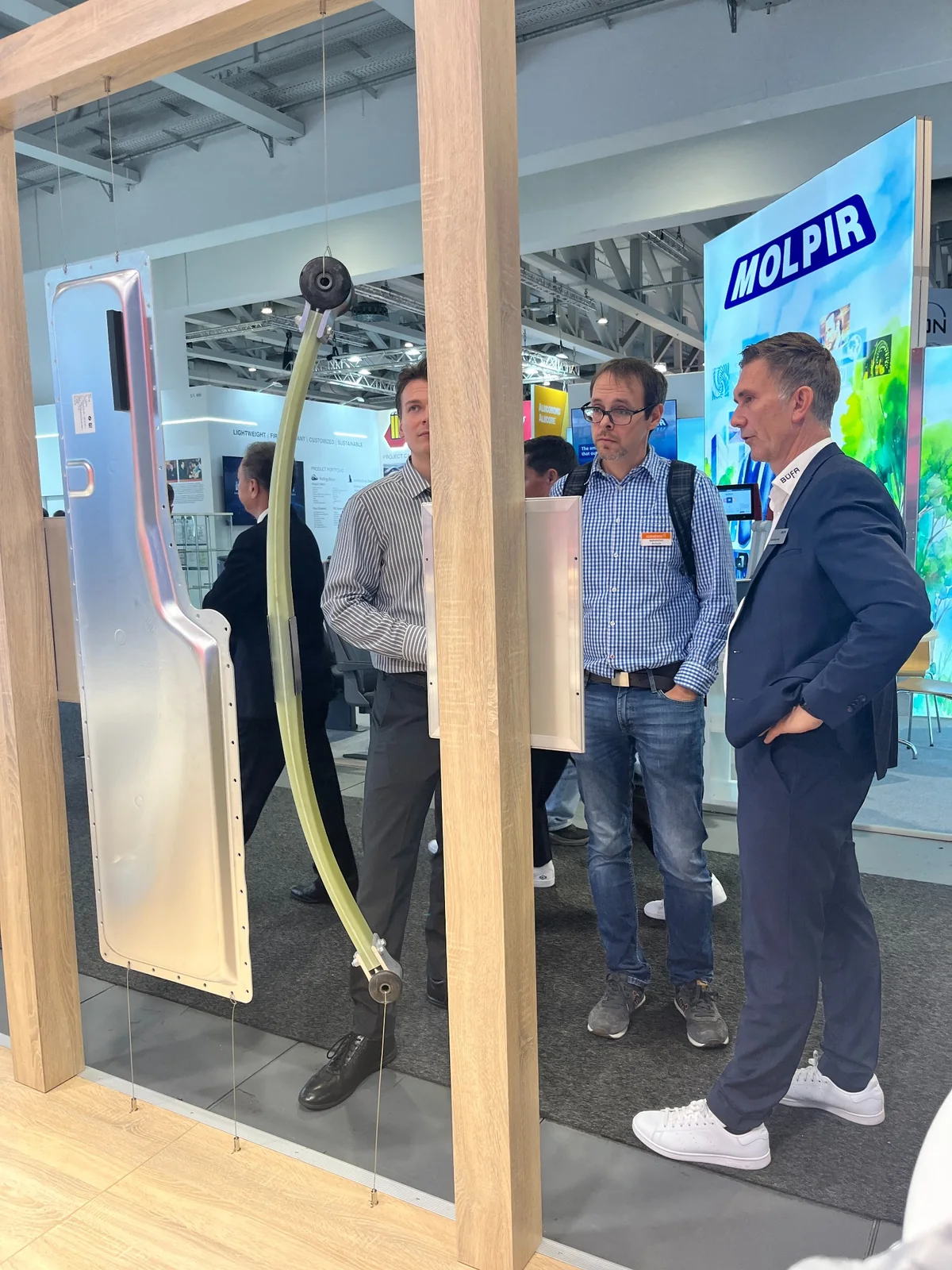 Participants standing beside the composite components on display at InnoTrans.